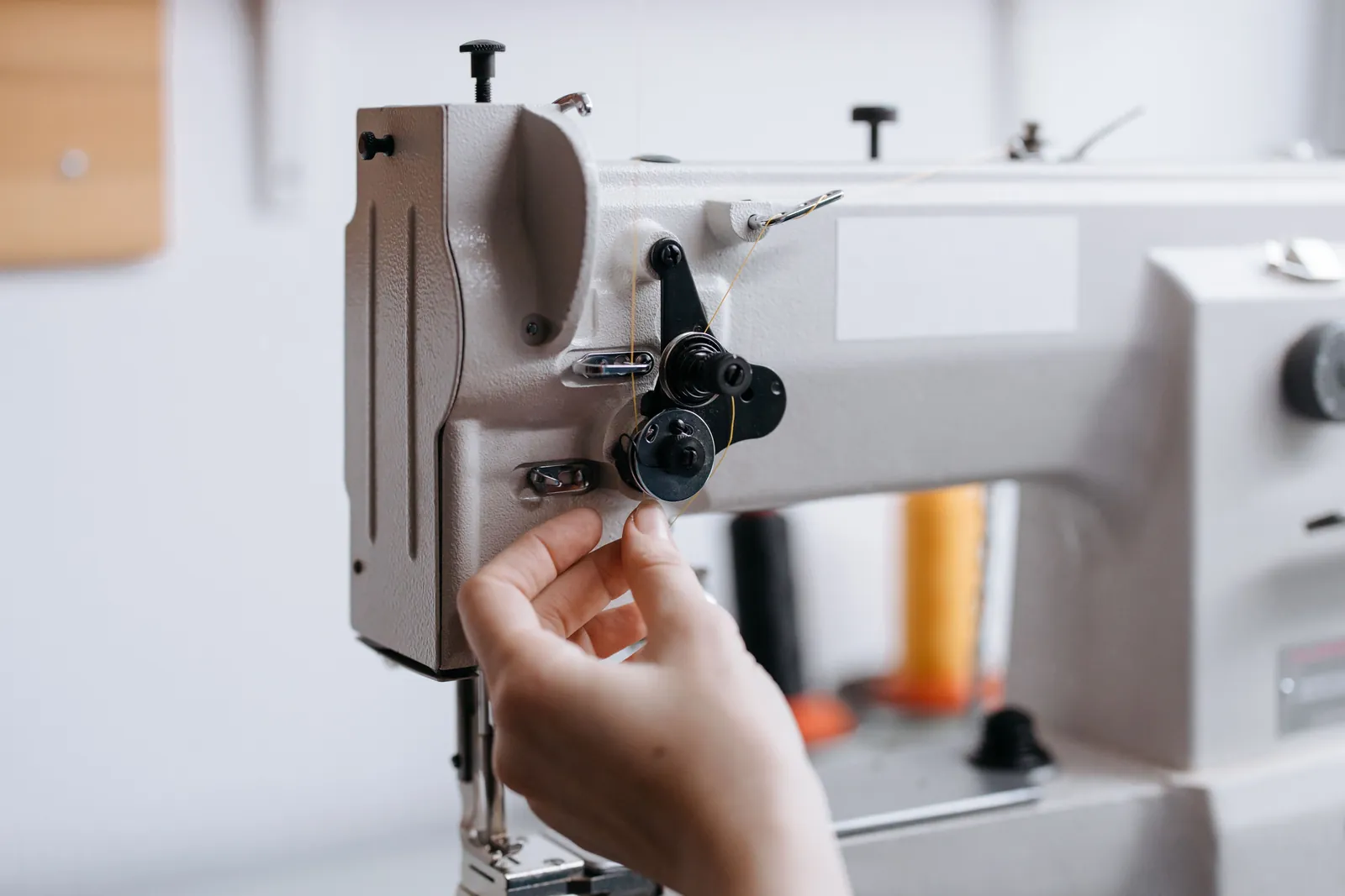 Operação em máquina de costura industrial em confecção