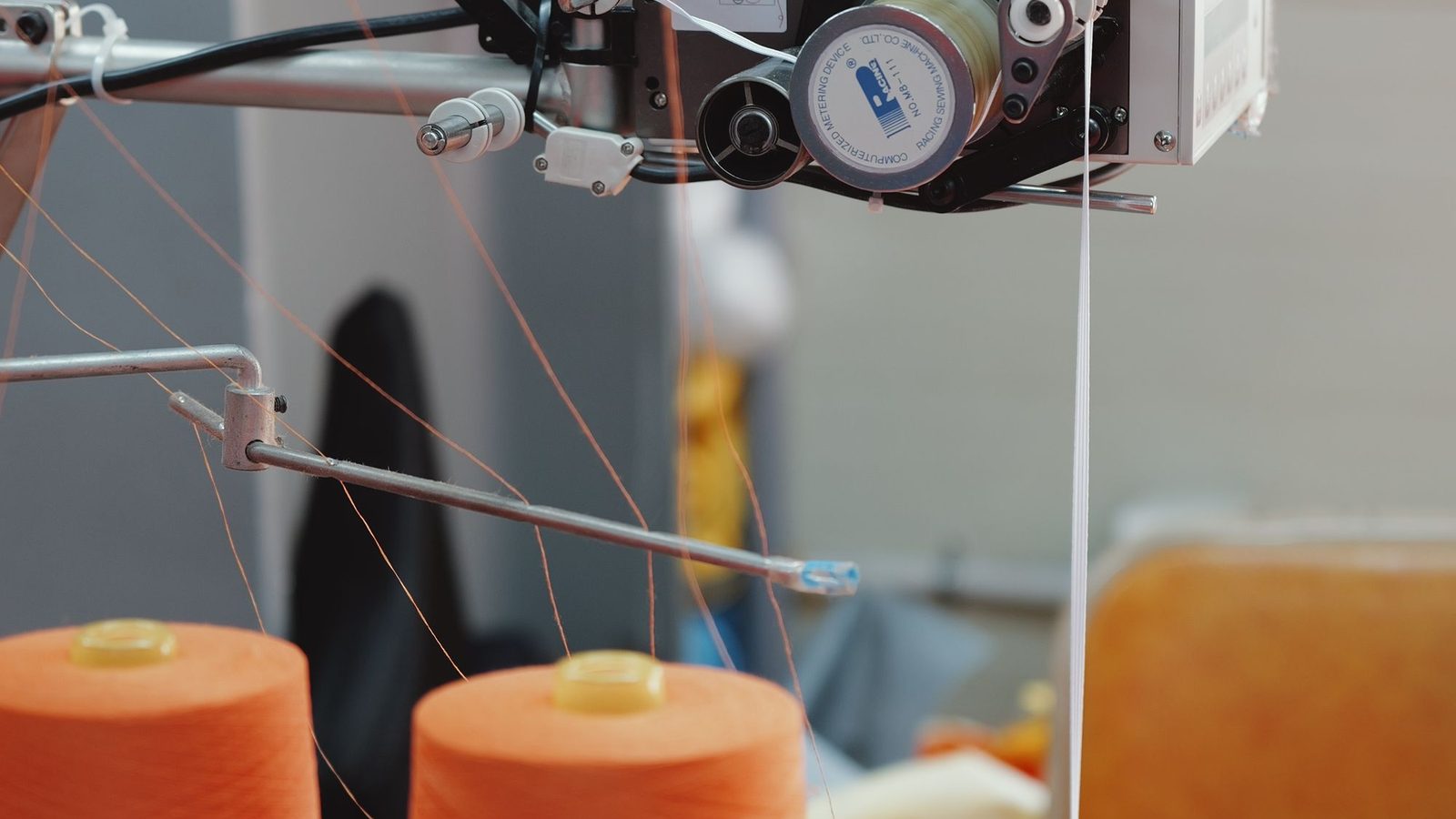 Máquina de costura industrial com cones de linha em confecção