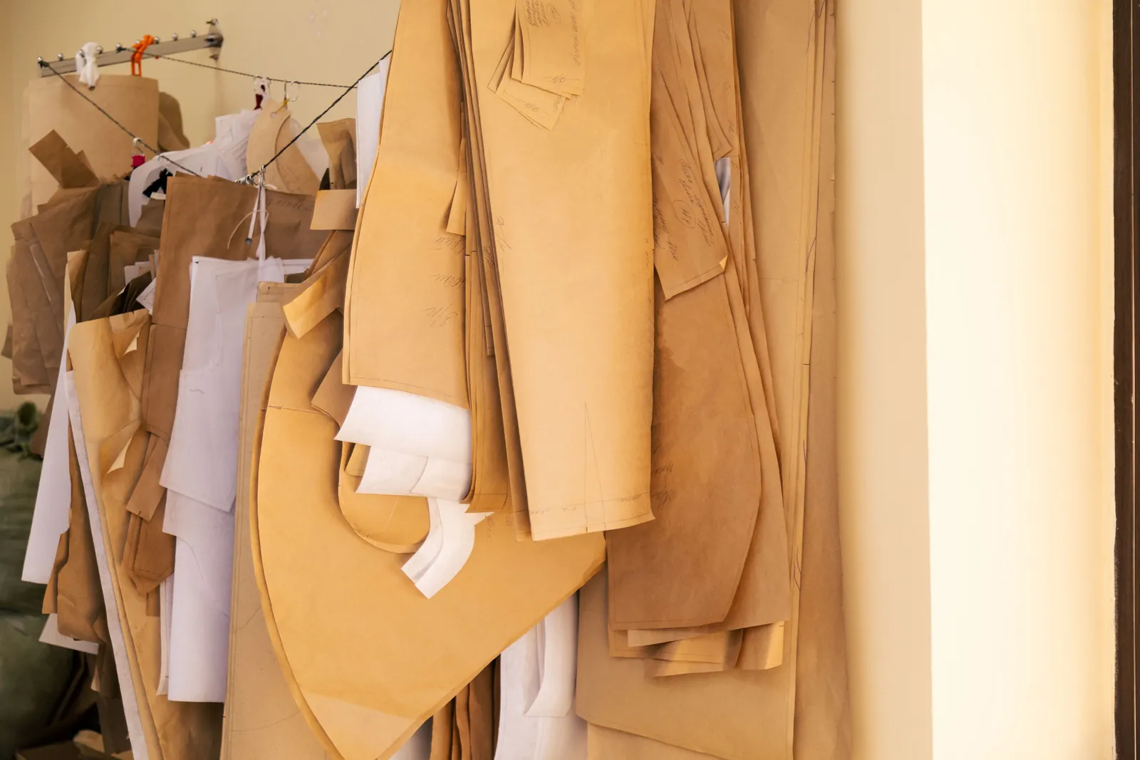 Moldes de roupa pendurados e identificados em confecção