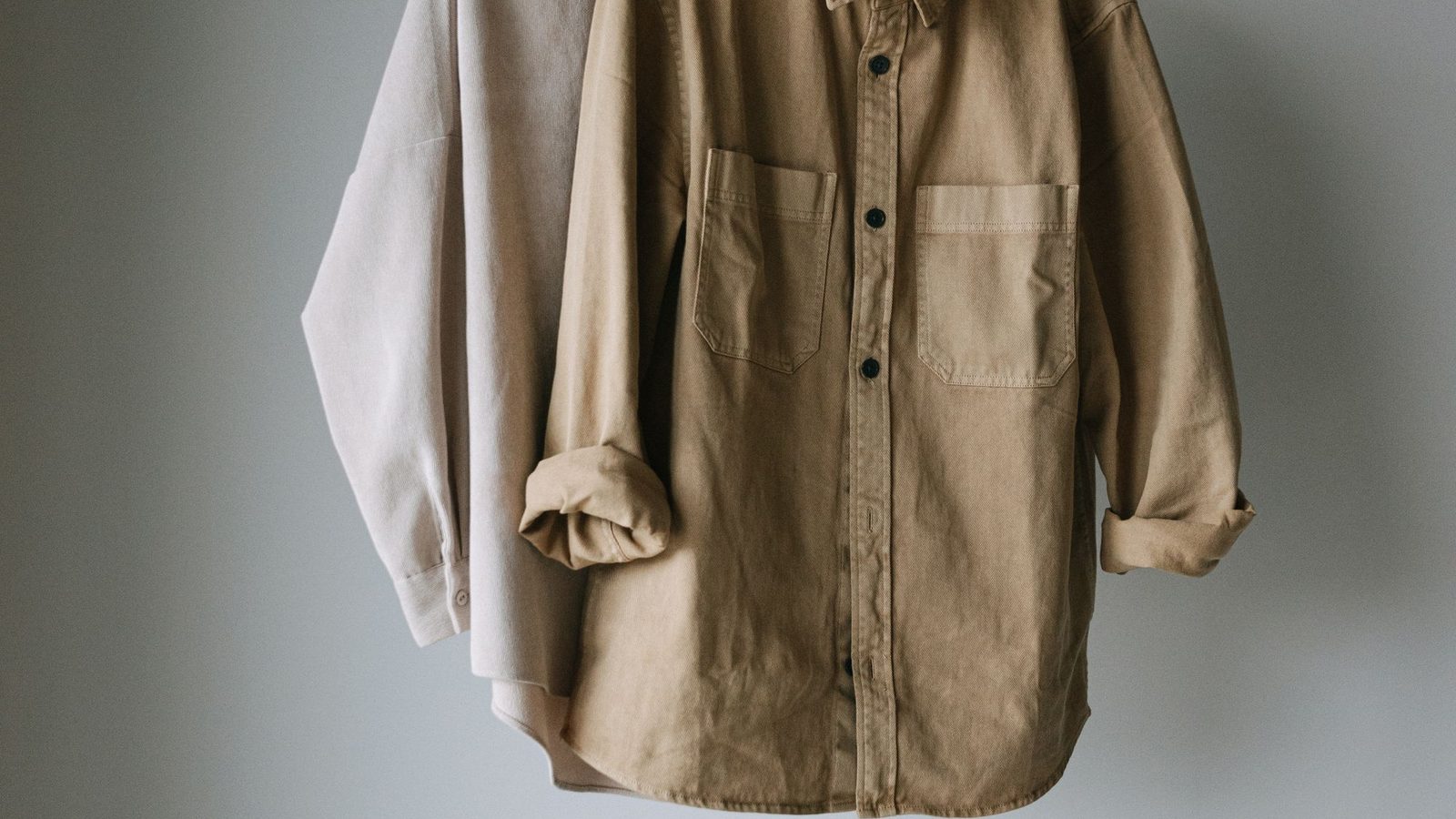 Duas camisas de tecido plano penduradas em arara